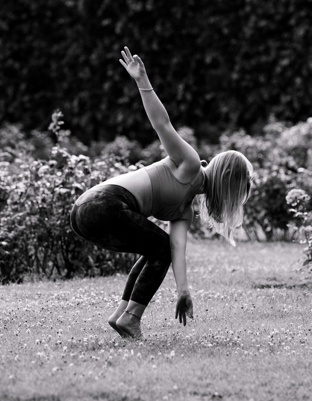 Eine Frau übt die Yogahaltung Parivrtta Utkatasana, gedrehte Stuhlhaltung.